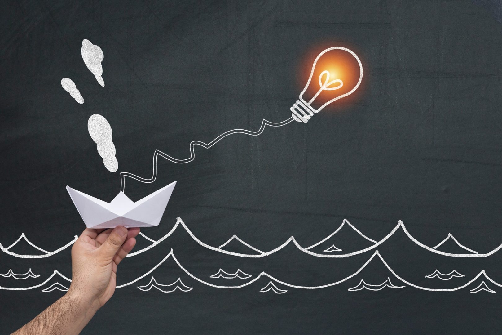 Paper boat hanging on the light bulb